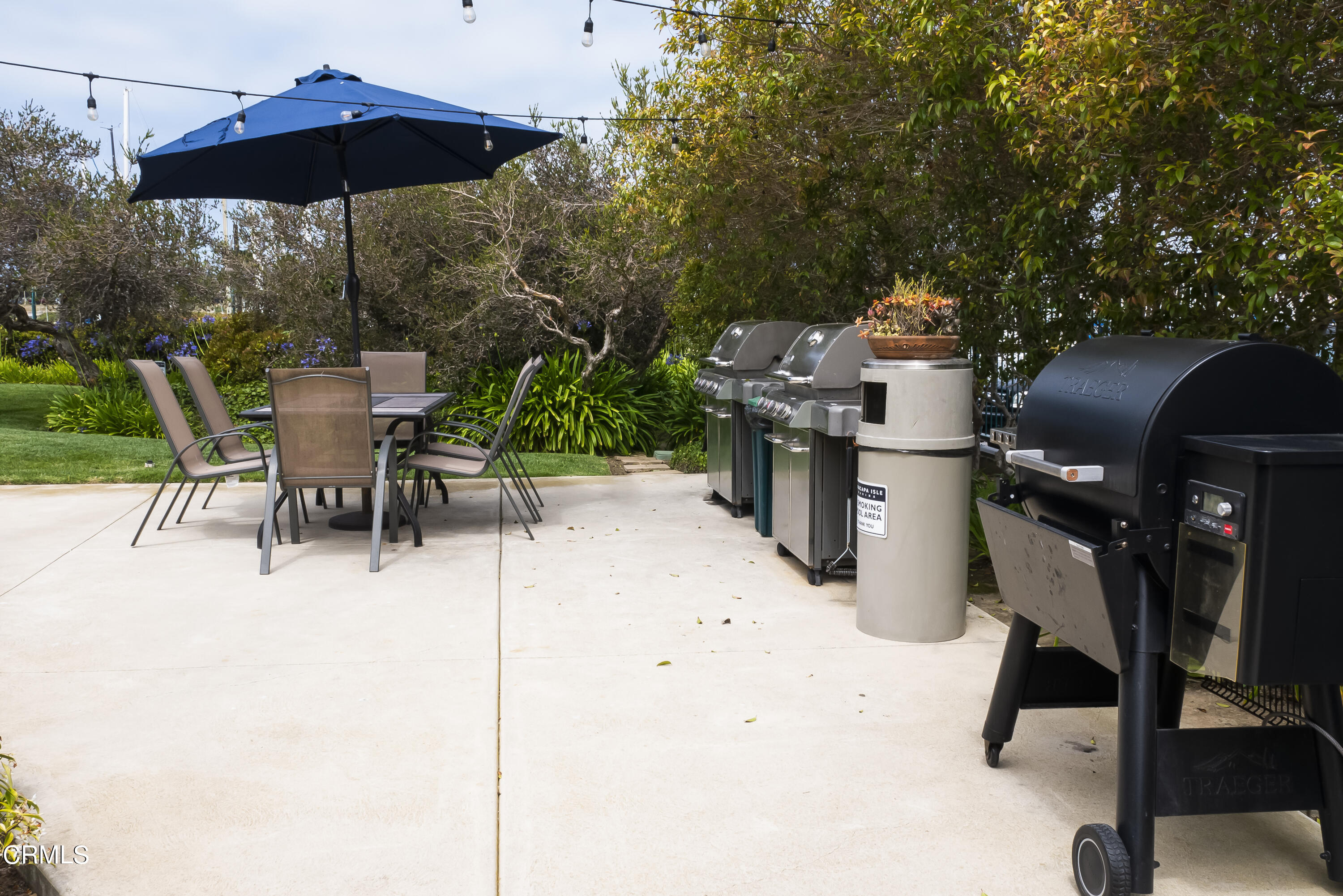 3101 Peninsula Road, Unit 307 Oxnard, CA 93035 - Photo 18 of 22 a view of a patio with chairs and table under an umbrella