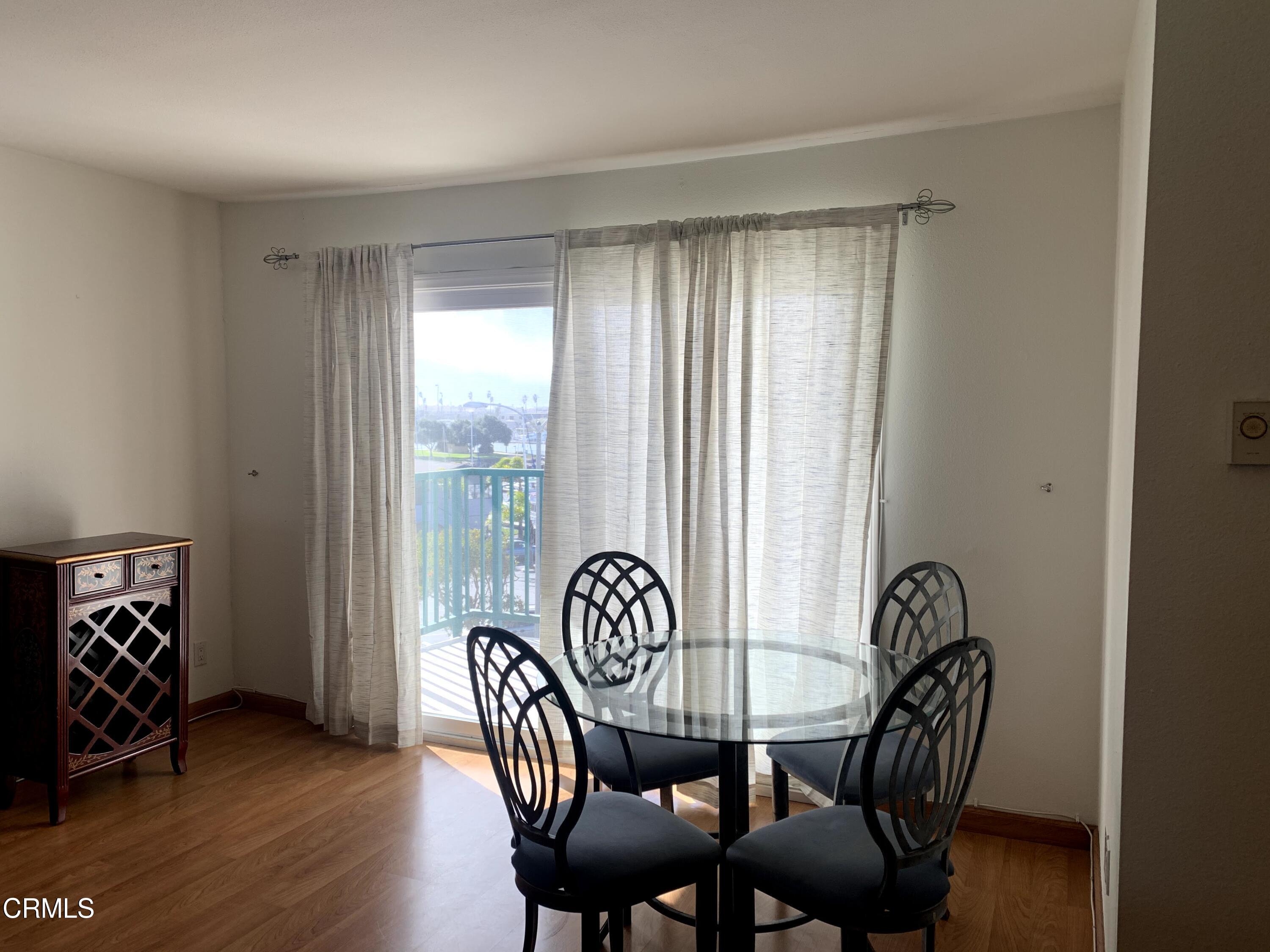 3101 Peninsula Road, Unit 307 Oxnard, CA 93035 - Photo 5 of 22 a view of a dining room with furniture window and wooden floor