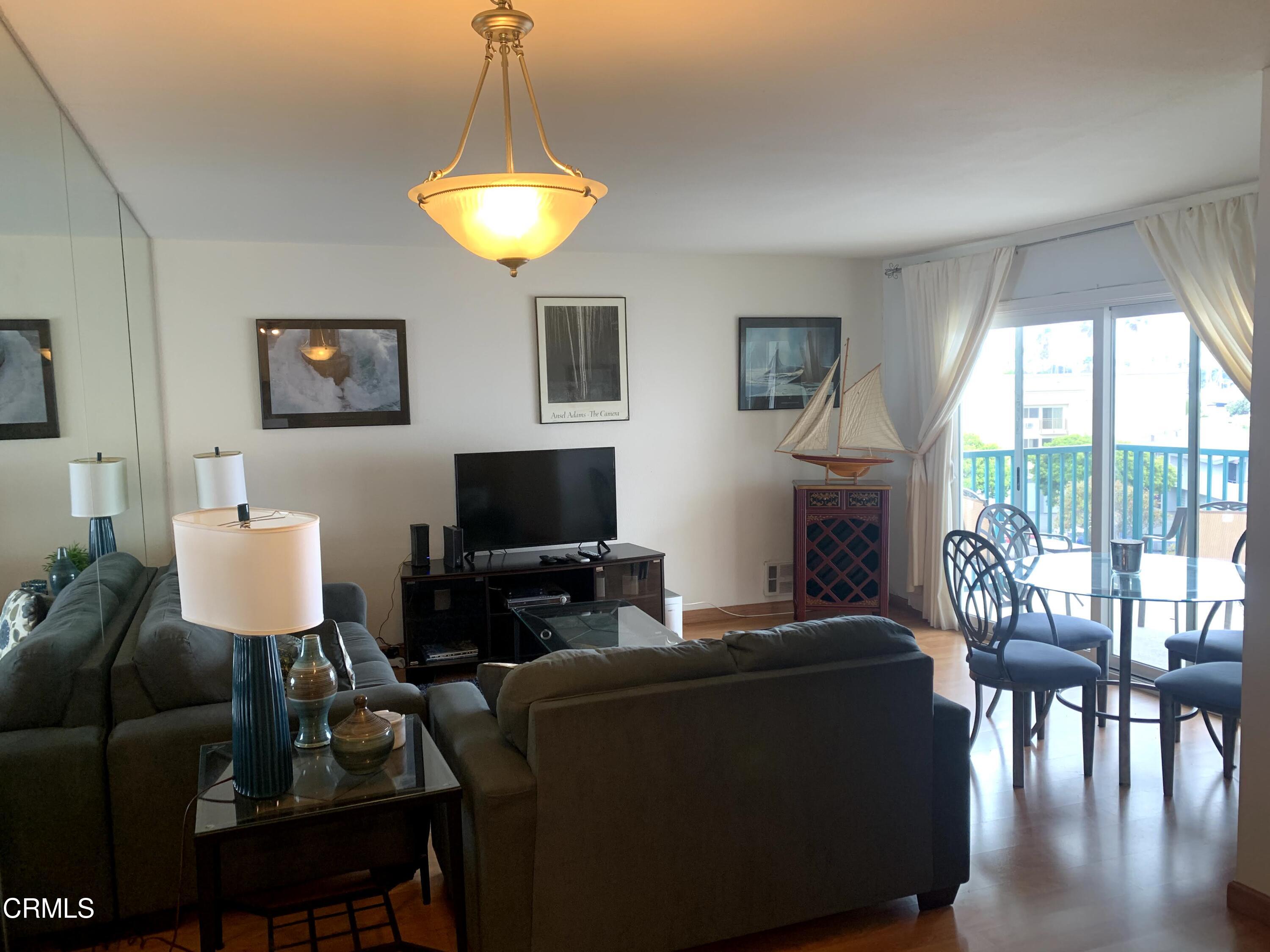 3101 Peninsula Road, Unit 307 Oxnard, CA 93035 - Photo 6 of 22 a living room with furniture a lamp and a flat screen tv