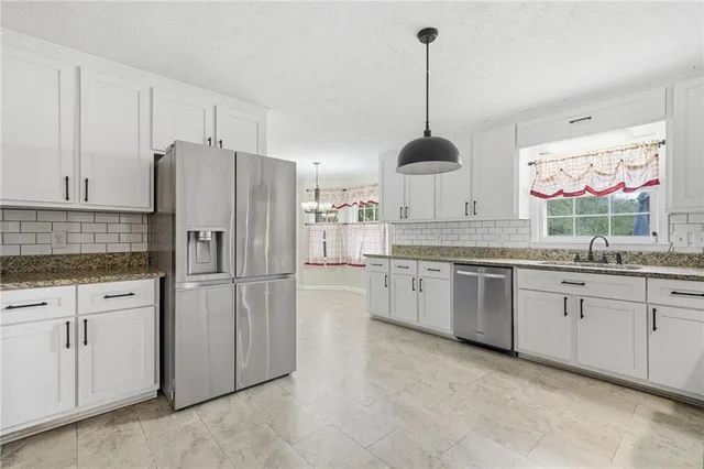 a kitchen with granite countertop white cabinets and white appliances