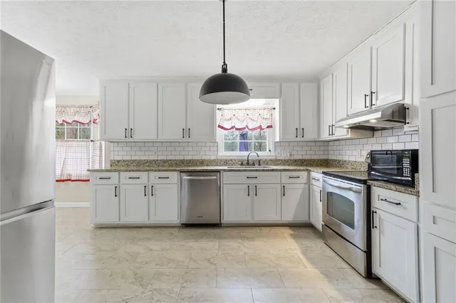 a view of a kitchen with a sink and refrigerator