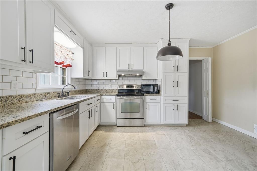 253 Newt Fowler Lane Canton, GA 30115 - Photo 21 of 35 a kitchen with stainless steel appliances granite countertop a sink a stove a refrigerator and cabinets