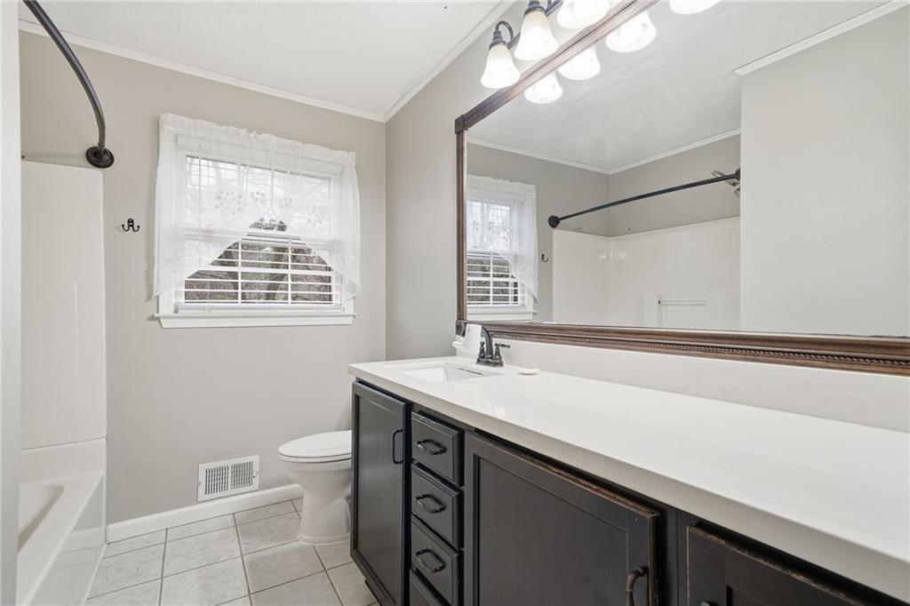 253 Newt Fowler Lane Canton, GA 30115 - Photo 30 of 35 a bathroom with a sink a toilet a mirror and a tub