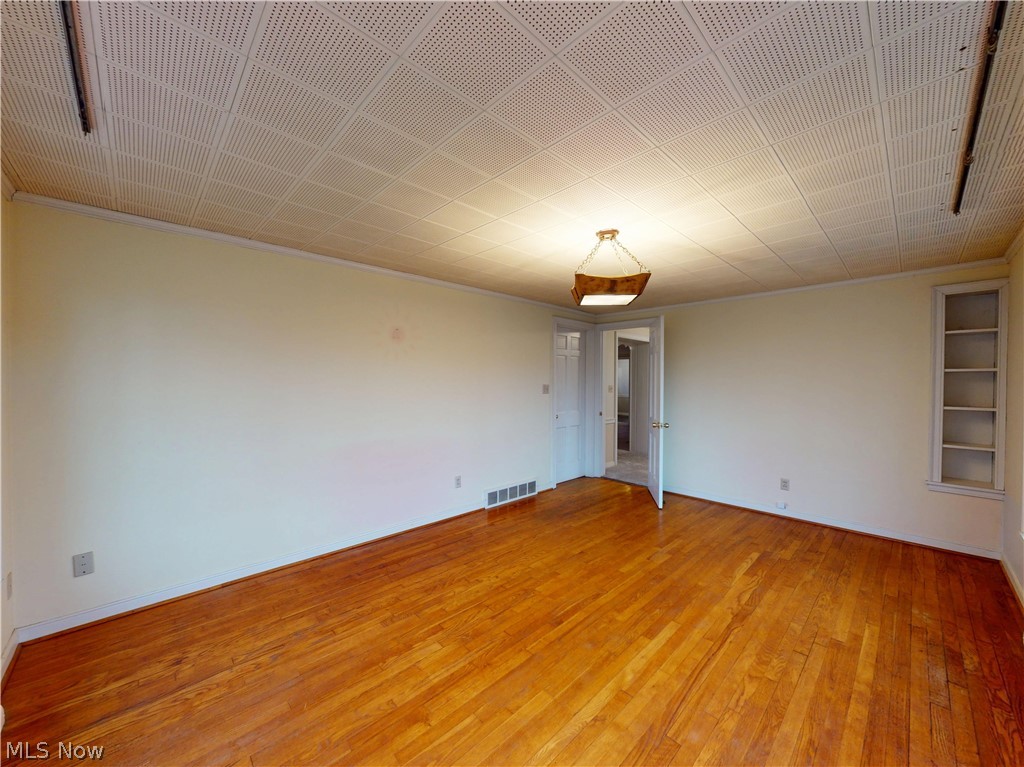 145 Overlook Road Painesville, OH 44077 - Photo 26 of 36 Empty room with built in features, light wood-style floors, ornamental molding, and french doors