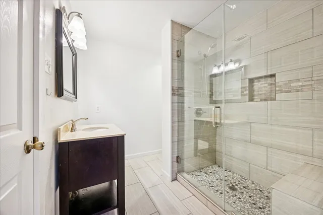 a bathroom with a sink a mirror and shower