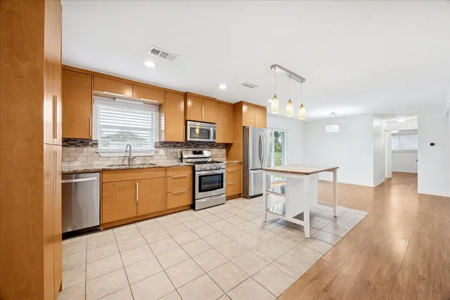 a kitchen with a sink appliances and cabinets