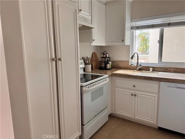 a kitchen with white cabinets and white appliances