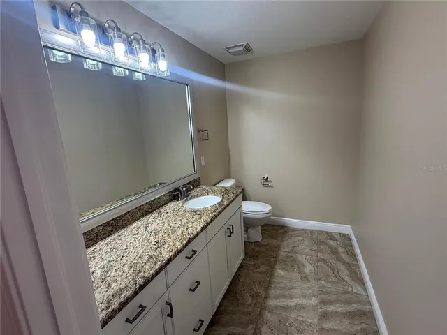 a bathroom with a granite countertop sink and a mirror