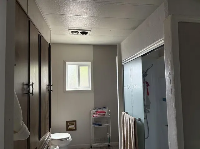 a bathroom with a toilet a sink and shower