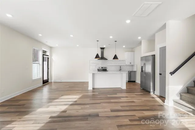 a view of kitchen with cabinets and refrigerator