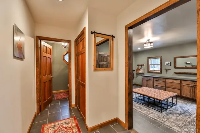 a view of a hallway with a livingroom with furniture and windows