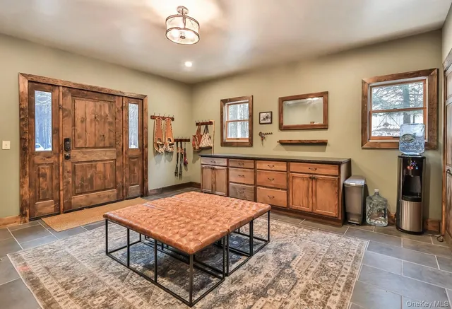 a living room with a dining table and paintings on the wall