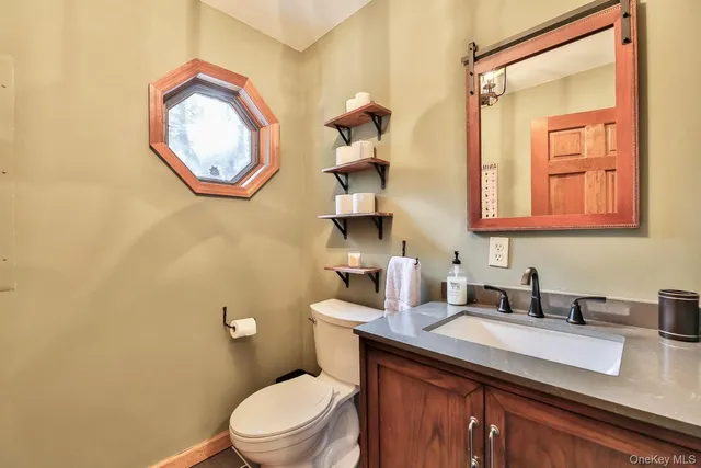 a bathroom with a toilet a sink and a mirror