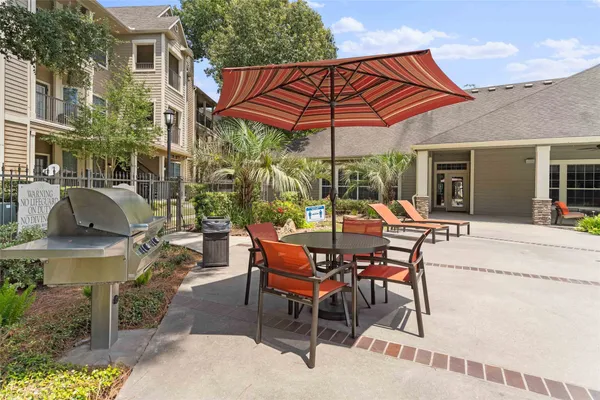 a view of a patio with table and chairs under an umbrella