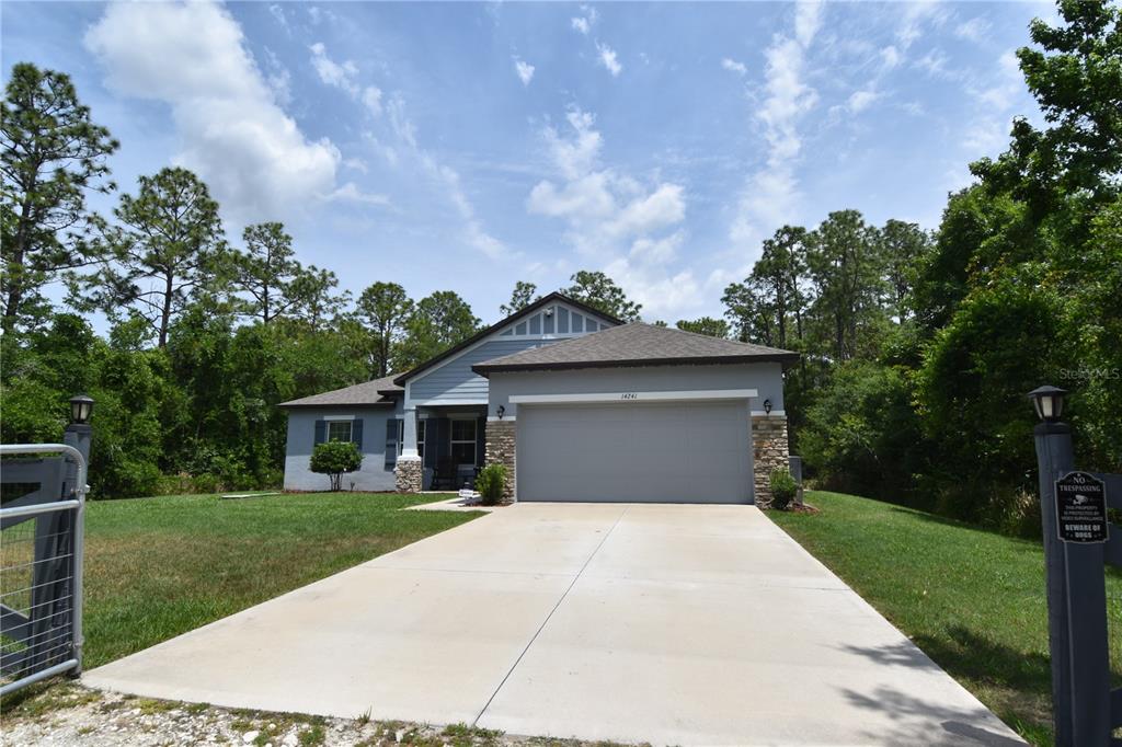 14241 Ravine Avenue Weeki Wachee, FL 34614 - Photo 1 of 48 a front view of a house with a yard and garage