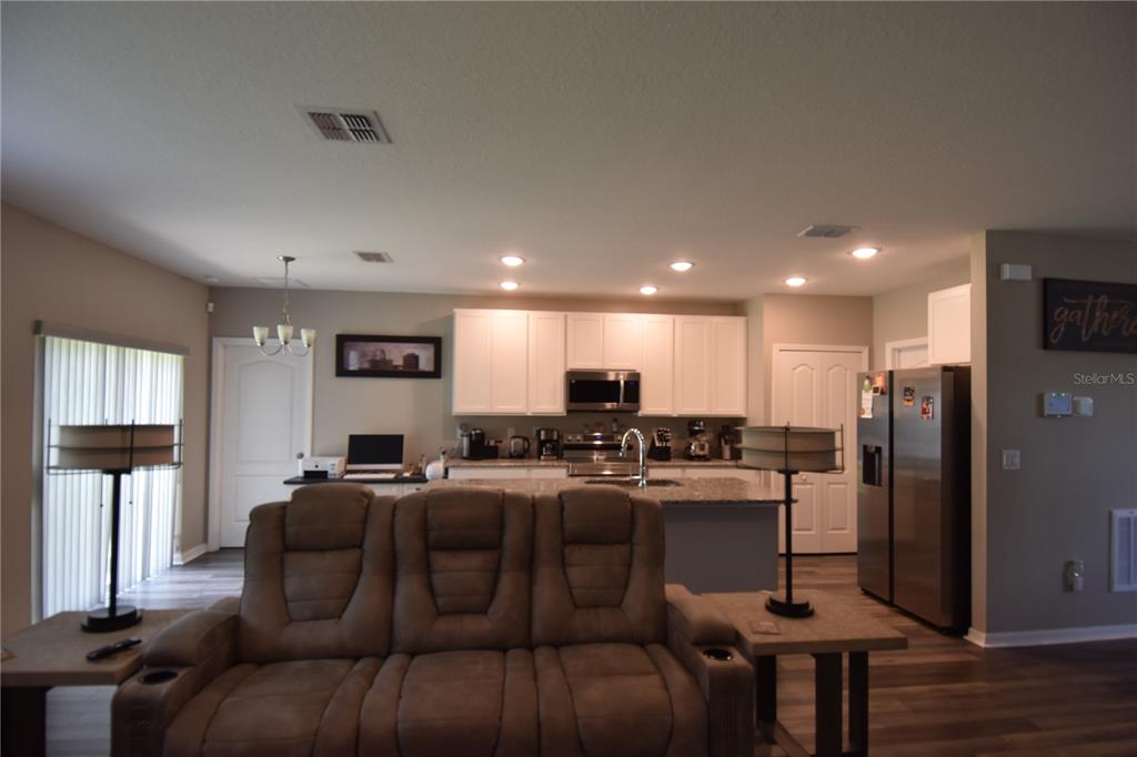 14241 Ravine Avenue Weeki Wachee, FL 34614 - Photo 25 of 48 a living room with stainless steel appliances kitchen island granite countertop furniture and a refrigerator