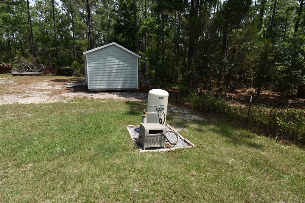 14241 Ravine Avenue Weeki Wachee, FL 34614 - Photo 29 of 48 a front view of a house with a garden and trees