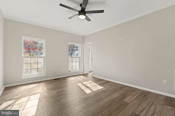an empty room with wooden floor and fireplace