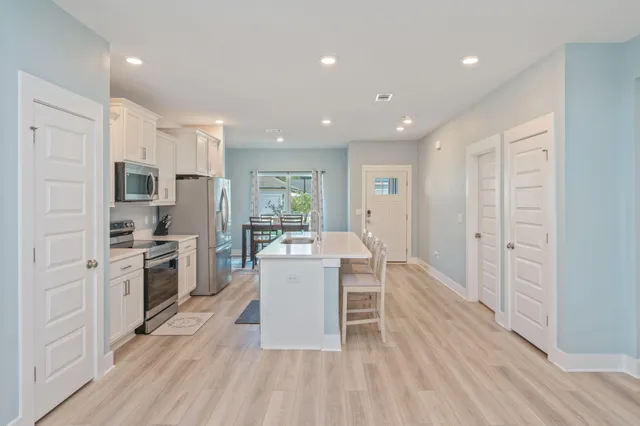 a kitchen with white cabinets and stainless steel appliances