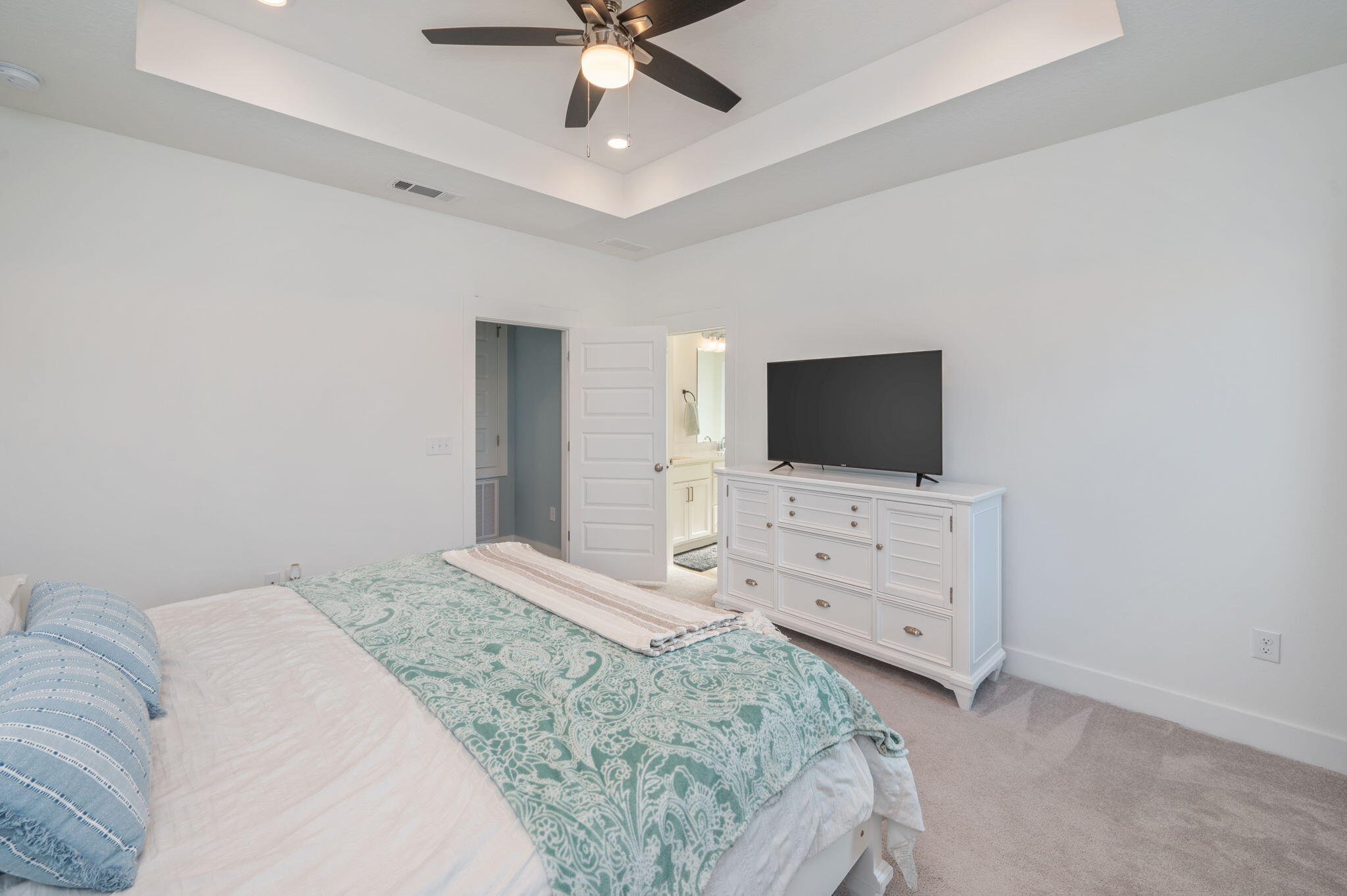 109 Blooming Cove Crestview, FL 32539 - Photo 29 of 42 a bedroom with a flat screen tv on the dresser and a chandelier