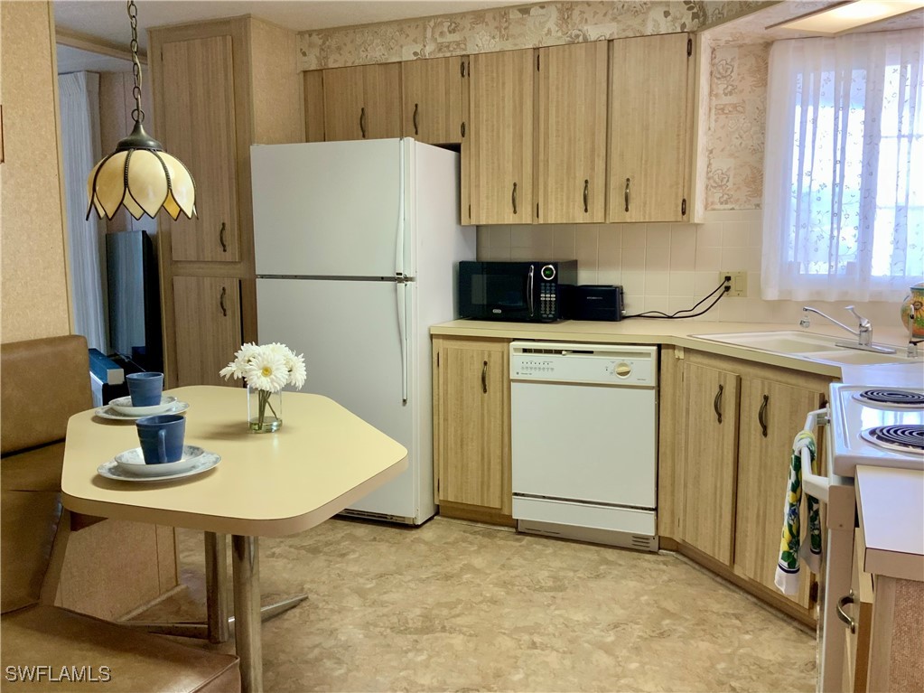 15550 Burnt Store Road, Unit 188 Punta Gorda, FL 33955 - Photo 11 of 37 a kitchen with a refrigerator sink and cabinets