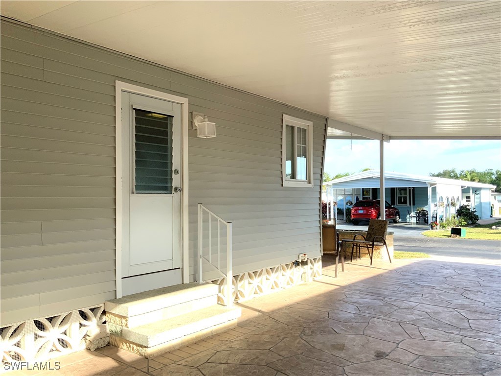 15550 Burnt Store Road, Unit 188 Punta Gorda, FL 33955 - Photo 9 of 37 a view of a patio with table and chairs and potted plants