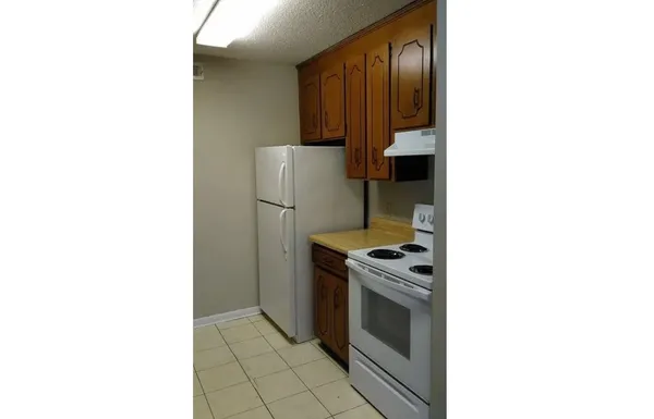 a kitchen with a stove cabinets and a refrigerator