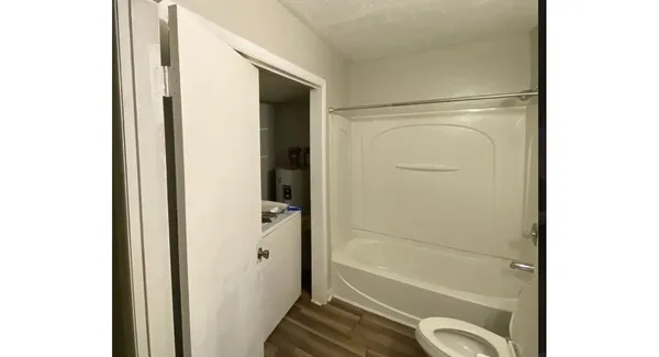 a bathroom with a granite countertop tub shower and a sink
