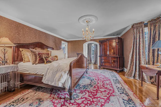 a bed room with a bed a chandelier and a rug