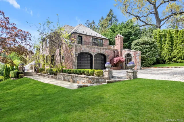 a front view of a house with garden and sitting area
