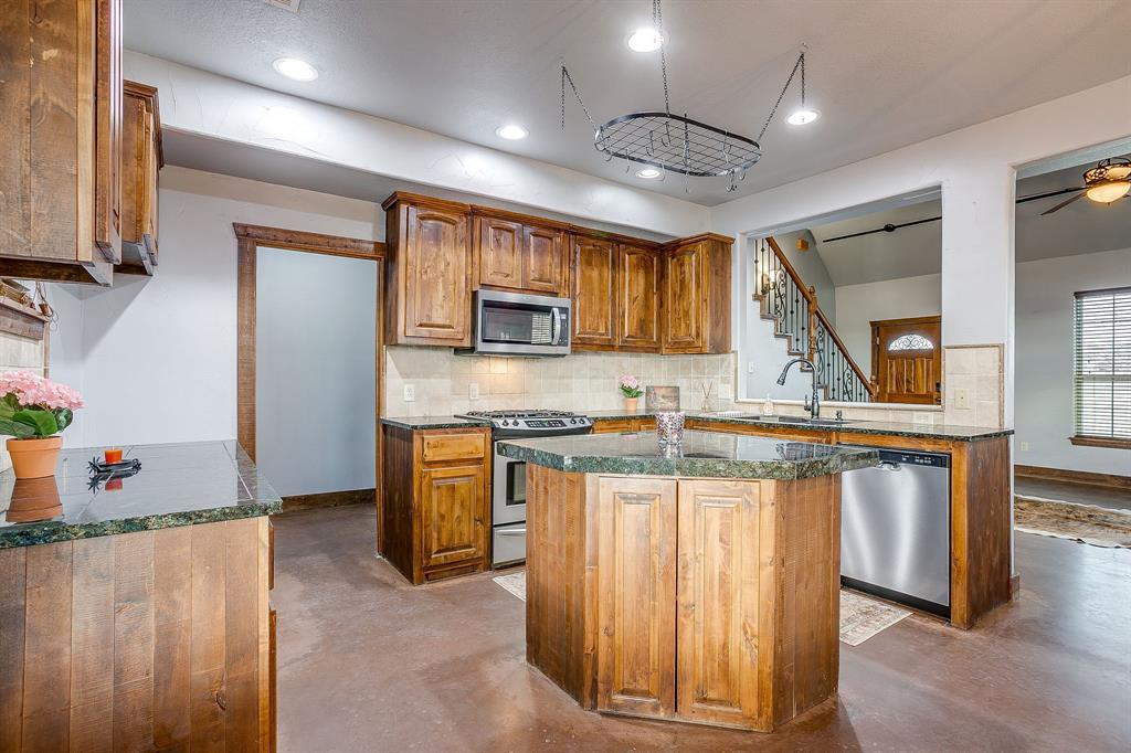 2220 Lazy Bend Road Millsap, TX 76066 - Photo 19 of 36 a kitchen with granite countertop a stove and a sink