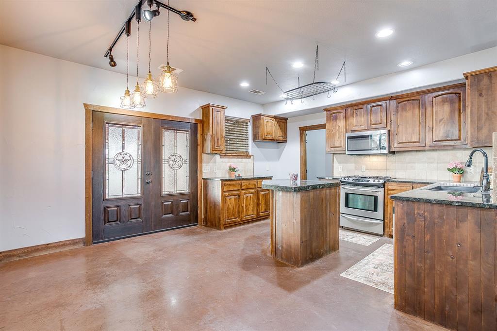 2220 Lazy Bend Road Millsap, TX 76066 - Photo 21 of 36 a kitchen with kitchen island granite countertop lots of counter top space and appliances