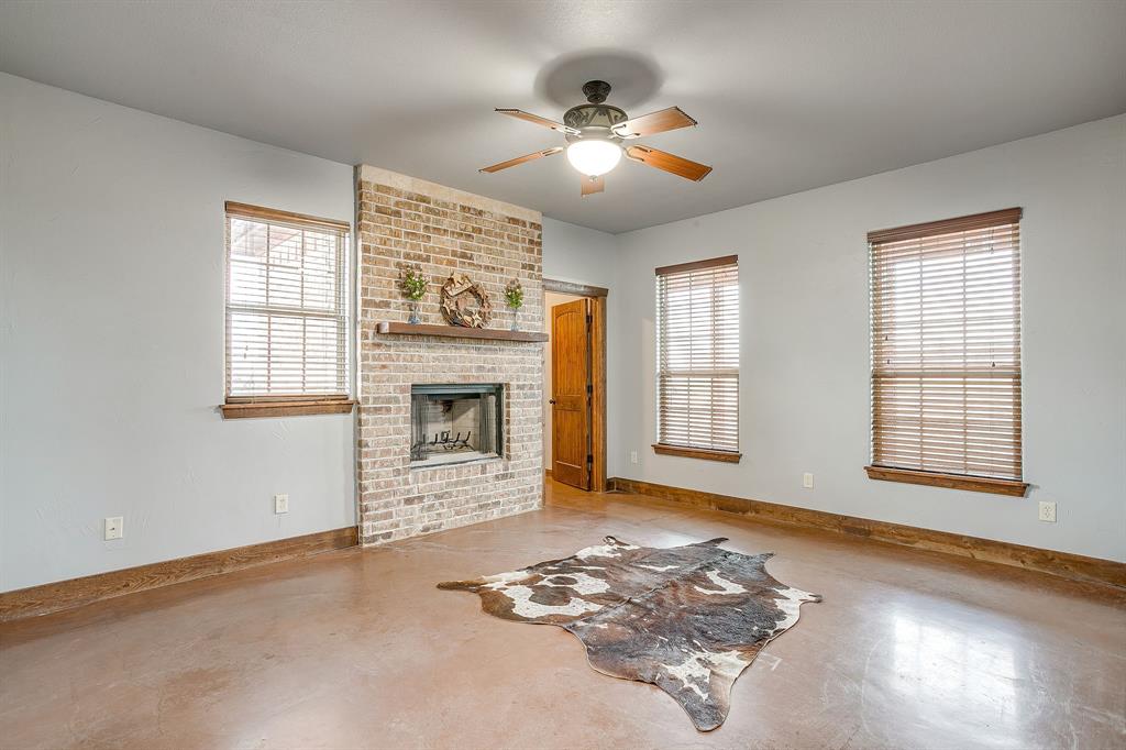 2220 Lazy Bend Road Millsap, TX 76066 - Photo 30 of 36 a view of a livingroom with a fireplace a ceiling fan and windows