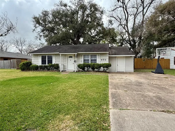 a front view of a house with a yard and trees