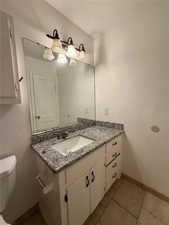 a bathroom with a granite countertop sink and a mirror