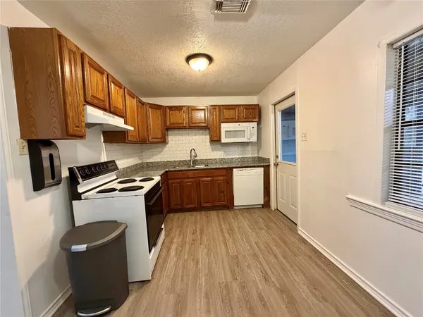 a kitchen with a sink a stove top oven a counter space and cabinets