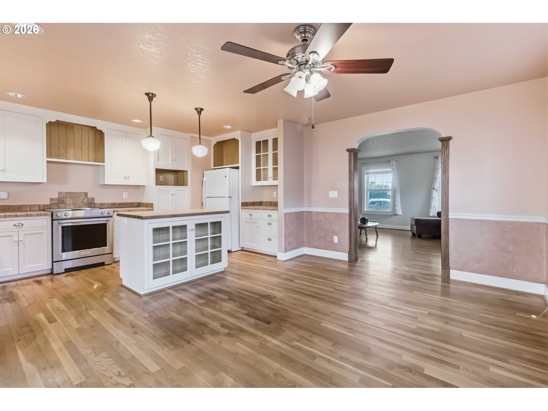 3008 Garfield Street Longview, WA 98632 - Photo 17 of 45 a view of a kitchen with a stove wooden floor a ceiling fan and windows