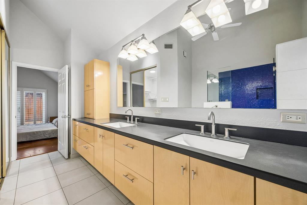 4115 Rive Lane Addison, TX 75001 - Photo 15 of 25 Spacious bathroom featuring a dual vanity with light-toned wood cabinetry and dark countertops