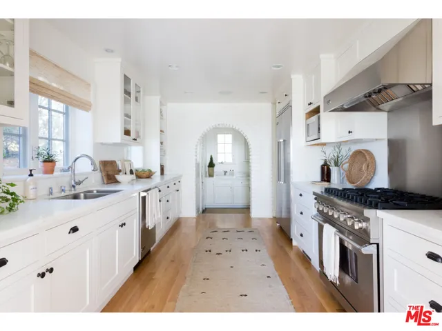 a kitchen with a stove a sink and a refrigerator