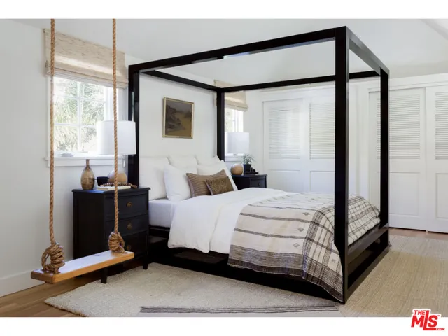 a bedroom with a bed and large mirror