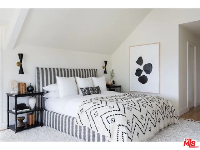 a bedroom with a bed and dresser with mirror