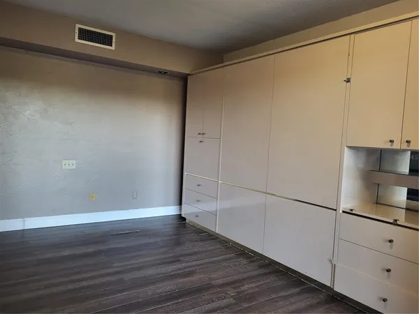 a view of a room with wooden floor