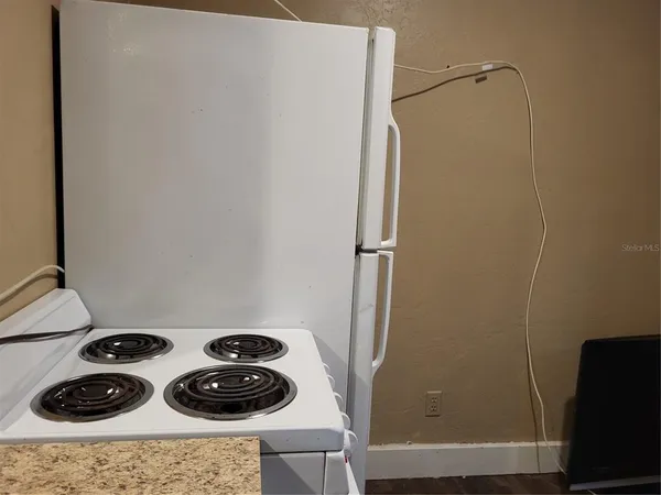 a kitchen with a refrigerator and a stove