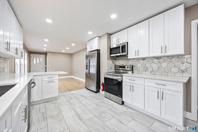 a large kitchen with cabinets stainless steel appliances and a sink
