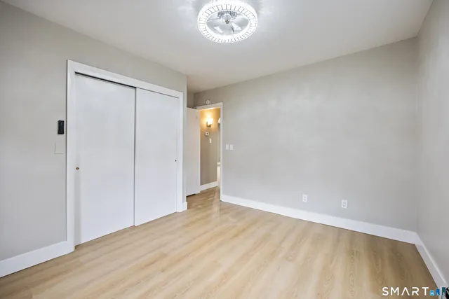 a view of an empty room and a kitchen