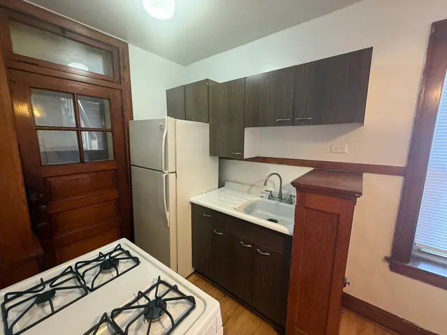 a kitchen with granite countertop a refrigerator stove and sink