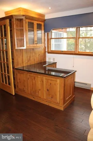 a kitchen with granite countertop wooden cabinets and a wooden floor