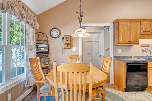 a spacious bedroom with a bed a dresser and a chandelier