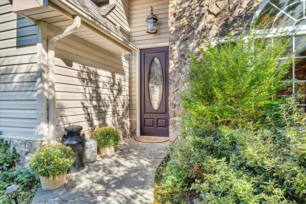 a vase with flowers sitting on a floor in front of a door