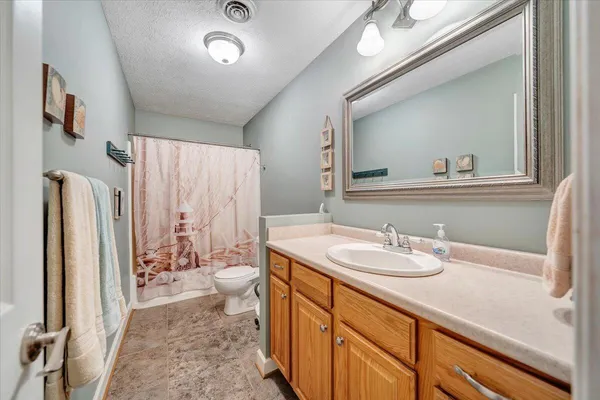 a backyard of a house with large trees and plants